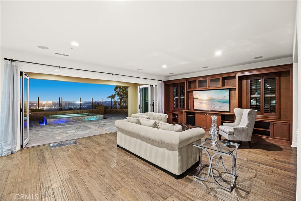 PRICE IMPROVEMENT! This stunning property offers breathtaking panoramic city and mountain views by day and captivating city lights at night. Located in the prestigious Montserrat neighborhood within the Blackstone Community, this 2013-built home has been impeccably maintained and features over $240,000 in upgrades.Spanning 4 bedrooms, 4.5 bathrooms, a loft, and a 3-car garage, this home is designed for luxurious comfort and functionality. Upon entering, you'll be greeted by engineered wood floors, recessed lighting, and custom plantation shutters throughout. The Great Room boasts a custom-built entertainment center with surround sound and impressive views, while expansive glass sliding doors provide seamless indoor-outdoor living. The spacious gourmet kitchen is a chef's dream, complete with Hazelnut cabinets, granite countertops, stainless steel appliances, a large center island, and a walk-in pantry. The main floor features a private in-law suite, perfect for guests or multi-generational living. Upstairs, a versatile loft area offers additional space for entertaining or relaxation. The master suite is a true retreat, featuring a walk-in closet with built-in storage and a luxurious en-suite bathroom. Each additional bedroom also includes its own private en-suite for ultimate convenience. Step outside to a beautifully landscaped backyard with a Jacuzzi that overlooks the city skyline, providing an unobstructed view of Disneyland’s fireworks and twinkling evening lights. This quiet, safe neighborhood includes security patrol and is situated within the highly acclaimed Brea Olinda Unified School District. The Blackstone Community offers resort-style amenities, including a junior Olympic pool, children’s playground, BBQ area, and dog parks. With easy access to the 57/90/91 freeways and proximity to Brea’s hillsides for hiking and outdoor activities, this home offers the perfect blend of luxury, comfort, and convenience. Don’t miss this incredible opportunity to own a truly exceptional home!