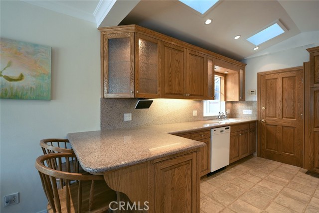 Granite backsplashes and countertops and red-oak illuminated cabinets