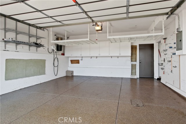 Spacious garage with EV charger and storage cabinets.