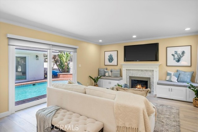 Living room with custom fireplace and built ins with sliding doors to pool area