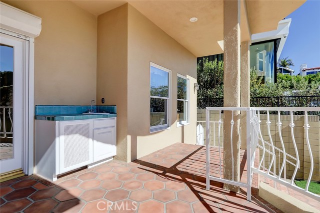 Private patio off downstairs family room with a outdoor cabinet with convenient sink