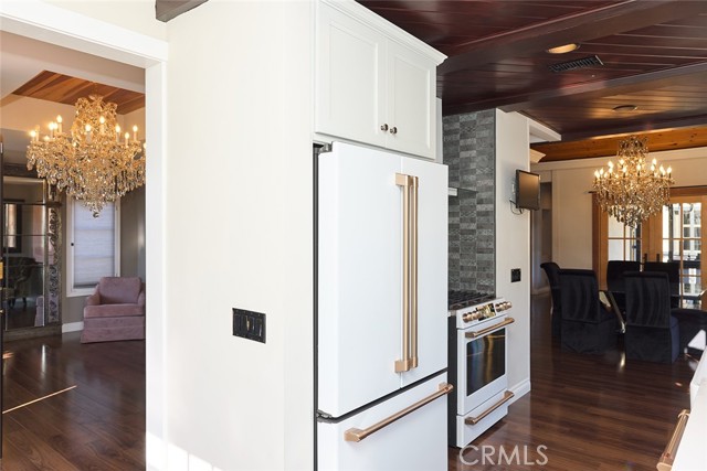 Cafe refrigerator and view of the foyer and chandelier