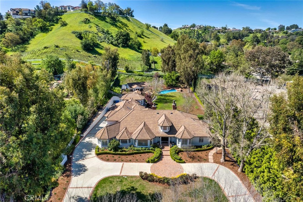 This immaculate and nicely upgraded estate residence is sited on one of the best cul-de-sac streets in all of Hidden Hills and features a prime central location. Highlights include a chef's center island kitchen with stainless steel appliances and adjoining, sunny breakfast room, a spacious family room with  open beam ceiling, wood burning fireplace, wet bar, and big picture windows overlooking the grounds, a large game/media room, spacious gym, custom office, and formal living & dining rooms, each with custom ceiling detail, plus wood and stone floors throughout. There are a total of 6 bedroom suites, including the first floor primary suite with wood burning fireplace, onyx bath & dual custom closets. There is also a complete guest house with kitchen & bath. The very private grounds include a sparkling pool & spa, large grass yard, full barbecue center, multiple patio areas, fruit & shade trees, circular driveway, and garages for four cars, with an additional car lift. This lovingly cared for home has much to offer.