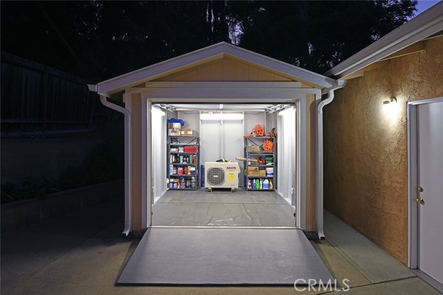 View of 10ft x 10ft motorcycle garage-workshop-storage area with wood ramp; 2-car garage (right)