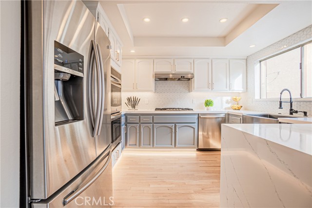 The elegantly remodeled kitchen, stunning quartz countertops, stainless steel appliances with dual ovens, and ample counter space and storage.