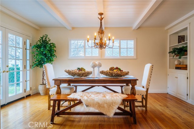 The elegant dining room with open beam ceilings includes built-in storage.