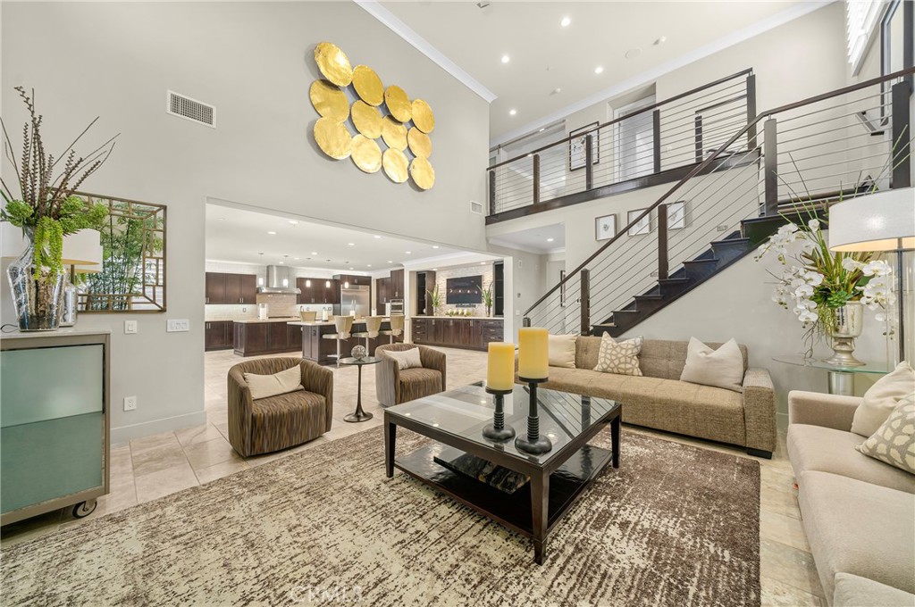 Every so often, a home emerges that redefines Modern Luxury! Step through the grand glass entryway into a thoughtfully curated space, where a grand office, a designer full bathroom, and an exquisite wine bar with a beverage fridge and expansive counter space set the stage for elevated living. The open-concept living area is anchored by a breathtaking floor-to-ceiling stone fireplace, while abundant natural light enhances the grandeur of the chef’s dream kitchen—featuring dual oversized islands, premium KitchenAid appliances, dual dishwashers, and custom cabinetry that exude both functionality and elegance. A spacious walk-in pantry offers ample storage. Throughout the home, recessed dimmable lighting and a built-in audio system allow for a perfectly tailored ambiance, whether it’s an intimate evening affair or a grand celebration. Every detail speaks of unparalleled luxury, from custom-made mirrors and designer-appointed bathrooms to elegant electric shutters, oversized glass shower doors, and classic plantation shutters adorning each window. Ascend to the upper level, where three beautifully designed en suite bedrooms feature highly upgraded spa-like bathrooms, while a versatile oversized game room provides endless possibilities for entertainment. The lavish primary suite is a true sanctuary, boasting double sinks, a walk-in shower, and a custom-built walk-in closet designed for the most discerning homeowner. A sophisticated, upgraded laundry room enhances convenience with ample cabinetry and a sleek built-in sink. Step outside into your private entertainment oasis, where a sprawling covered patio with a cozy fireplace overlooks a newly built, resort-style swimming pool and spa. The custom clear glass fire pit, tranquil water fountain, and oversized BBQ area set the stage for unforgettable gatherings. The meticulously landscaped front and backyard feature a state-of-the-art irrigation system, ambient lighting, and a cutting-edge security system for ultimate peace of mind. The garage is a functional masterpiece, equipped with custom cabinetry, epoxy flooring, and an EV charging station. Paid-off Sullivan solar panels, tankless water heater and a whole-house water filtration system elevate the home’s efficiency and comfort. Exclusive access to the prestigious Aliso Viejo Country Club and to Glenwood Aquatic Center’s with an Olympic-size swimming pool. Top-rated schools, exquisite fine dining, and California’s most coveted beaches are just minutes away.