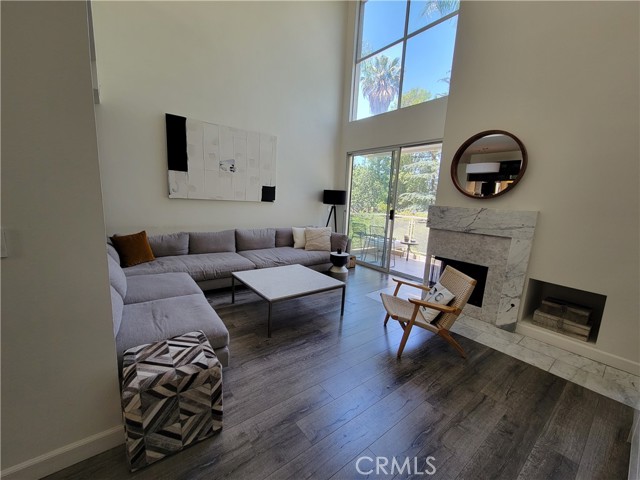 Living room with 2 story high ceiling, balcony w/view of trees, FPLC