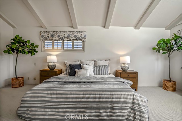 Primary Bedroom is south side with high beamed ceilings.