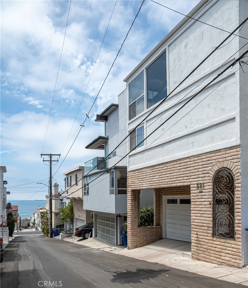 Coastal views and steps to downtown Manhattan Beach is what makes this multi-story property a remarkable beach home. The upper-level family room, kitchen, and dining area are melded together to create a spacious open floor plan that connects to a western facing balcony and peaceful ocean breezes. Floor to ceiling windows allow light to permeate throughout and recently added hardwood floors create a clean and contemporary space. The kitchen offers abundant cabinet space and bar seating to form an effortless space to enjoy with your guests. The middle level features the main en-suite with walk-in closet and a fully remodeled bath with soaking tub, glass shower, and stylish finishes. Two additional bedrooms and hall bath are also included on this floor. Be creative with the lower-level bonus room with its own private entry and back patio making this an ideal space for a 4th bedroom, home office or second family room- maximizing the home’s livability. Bonus features include central air conditioning and a two-car attached garage. Located in the highly sought-after sand section, just a short distance to the beach, downtown’s shopping and dining district, and the award-winning Grandview Elementary School.