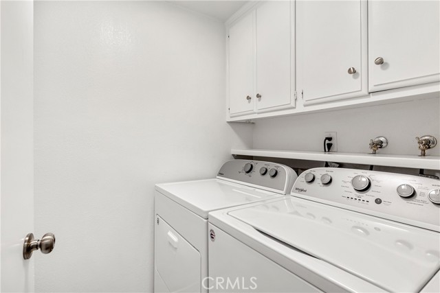 Laundry room with storage cabinets.