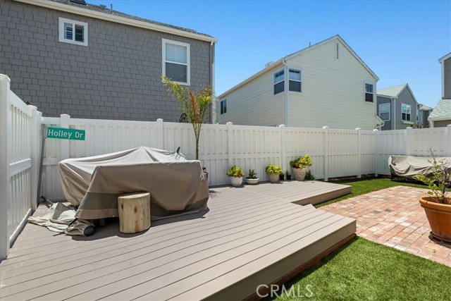 Entertaining backyard with turf, raised deck and vinyl fencing