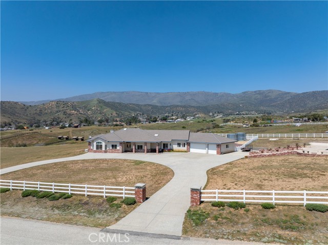 4403 Pelona Cyn Rd, nestles peacefully between the Sierra Pelona & San Gabriel mountains, lending majestic views offered from this stunning single story homes wonderful layout. Located on 6.3 acres, approx. 99% fenced, usable & well kept, not only do you receive the open space you have been yearning, but a home that fits the needs you have sought after for so long. You are invited into an open concept as you cross the threshold. 14ft vaulted ceilings in the great room, with custom h/wood entertainment center, recessed lighting, wet bar & h/wood flooring. Wood burning fireplace is an invite to kickback & relax & listen to music through the whole house surround sound system. Serving home cooked meals just became a joy. Oversized center island with 4 burner & griddle (DCS) stove top. Built in M/wave & Electric oven. Hang down see thru h/wood cabinets recessed lights, granite c/tops plus breakfast bar & kitchen nook. For a more intimate dining, a separate room offers a place for just that. 12ft vaulted ceiling in the generously spaced primary master, with a step down sitting area, gas f/place, h/wood floors, walk in closet plus a bathroom with oversized shower stall, jetted tub, duel sinks, vanity & wood cabinetry. 2 bedrooms have ample closet space, accommodating family/guests who just may stay a while. You will find an elegant decorative flower pedestal sink & toilet in bathroom #1, with skylight, h/wood cabinetry & tile flooring. Bathroom #2 has been tastefully remodeled with oversized shower, duel sinks, granite countertops & skylight. Laundry may not be your favorite pastime, but it might be with this fab space with a basin, countertops & cabinetry plus built in ironing board. The office. It will be a pleasure to work from home. Built in bookshelves, & desk. Come look at the oversized 1100 sq. ft. 3 car garage with 8ft entrance, cabinets galore, full sized dog bath, circulating pump, & work bench. Exterior of home offers a covered patio, front & back, ceiling fan outlets, vinyl picket fence. Artificial turf at rear, decorative rock landscaping, play area with swings & slide. Stamped concrete horseshoe d/way in front of home. The pool house. WOW. 1890 sq. ft. 18 x 36 pool, gas heated, 8ft max depth, forced air ducting, covered patio at front, truly a pool for ALL seasons. BBQ at rear. Whole house stand by generator, natural gas powered, auto start & stop. Oversized storage shed to hide the tools. Come find me. I am 4403 Pelona Cyn & YOU can call me HOME.
