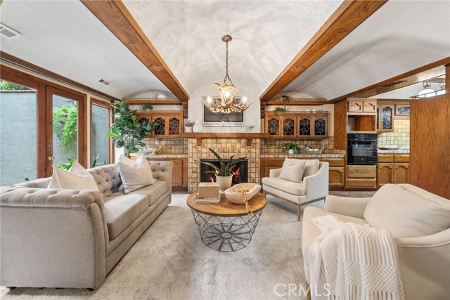 Family room w cozy fireplace and french doors to center patio