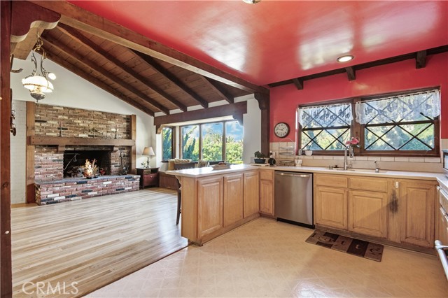 Kitchen & breakfast bar view to great room brick fireplace.