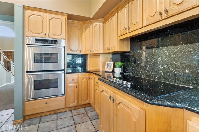 So much space to keep yourself organized and double oven to bake your favorites. Cooktop to the right of the image with granite backsplash makes it easy to keep clean.