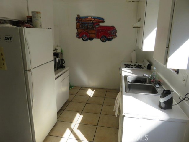 Unit #3 kitchen. Tile floors are nice. Laundry hookup in corner.