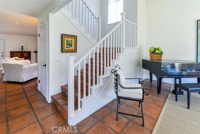 View from the entryway showing living room, stairs, storage under the stairs and the family room down the hall.