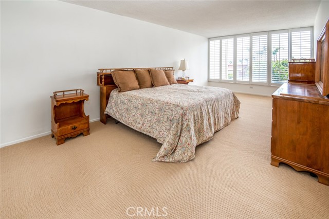 Oversize master bedroom with plantation shutters and His and Hers closets.