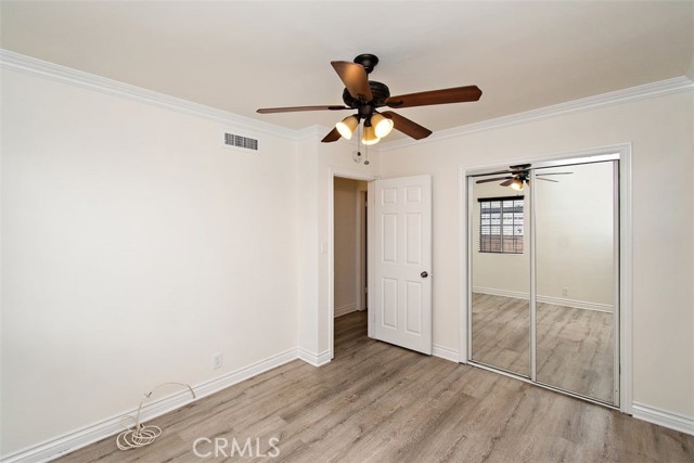 Bedroom 2 with ceiling fan and mirrored closet door