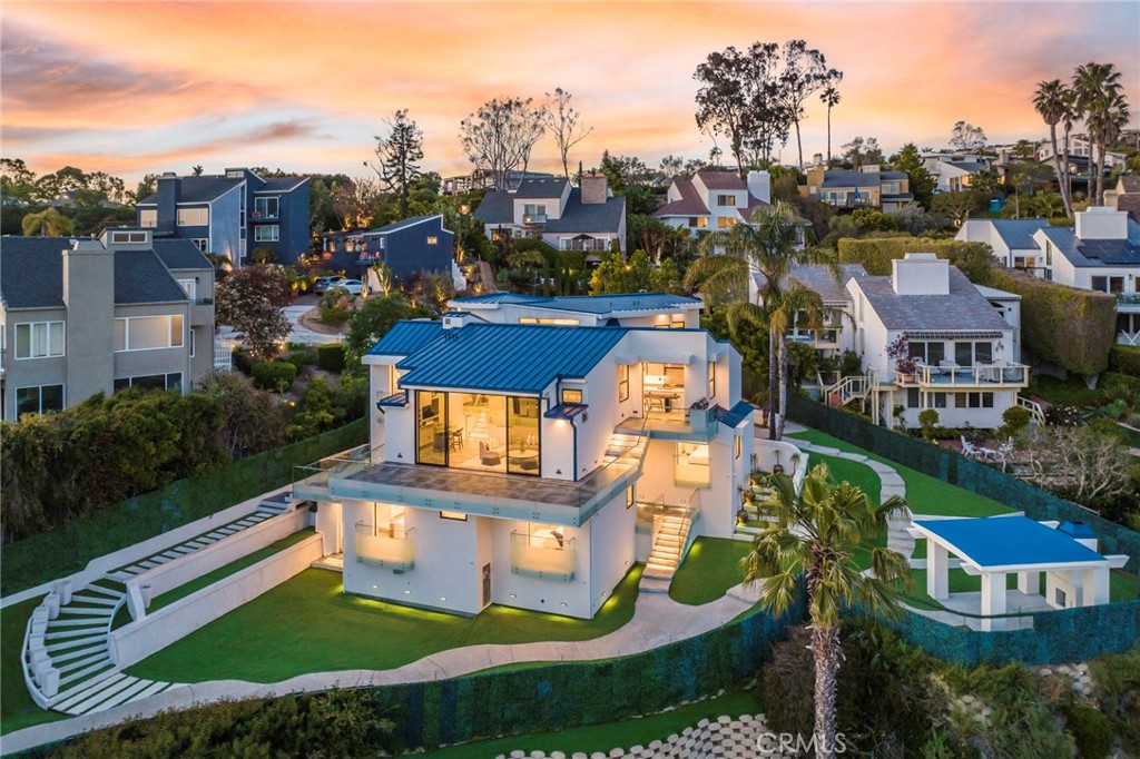2135 Hillview Drive is a meticulously updated contemporary offering, extensively and carefully remodeled down-to-the-studs in 2023. Featuring a prime location in the Park Estates section of Laguna Beach, this property is sited on an expansive, approximately 20,650 square foot lot. With nearly 5,100 sqft of living area, this home is comprised of six spacious bedrooms with all but one offering spectacular ocean views. Modern elements abound throughout this house, with a dramatic double-height foyer greeting all visitors. The entertaining area was thoughtfully designed to occupy two levels, offering both space and separation. The upper one is comprised of a bright kitchen with an oversized island, a walk-in pantry with a wine fridge, and access to one of the home’s many decks. Adjacent to the kitchen, the large dining area looks towards the ocean as well as onto the secondary entertaining level below with dual fireplaces and access to the property’s largest deck. The primary suite occupies its own floor for ultimate privacy and features ocean views from both the bedroom as well as the bathroom with a standalone jacuzzi. The secondary bedrooms are conveniently located on various levels of the home, lending themselves to be used as home offices or additional living areas. The backyard offers several multipurpose areas, including an elevated covered patio with a fireplace for year-round enjoyment. Additional notable features include full-home automation, backlit agate elements, numerous balconies with Fleetwood doors, and a three-car garage with Italian tile flooring. A stone’s throw from all the city is known for, from restaurants and boutiques to its famous beaches.