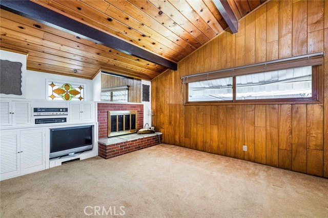 Den off living room with its own fireplace, beautiful wood wall and ceiling