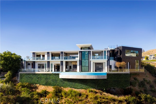 1622 Viewmont Drive Los Angeles, California Luxury Live Auction! Bidding to start from $12,000,000! An opportunity such as this rarely presents itself. This is one of the finest new construction homes built in Los Angeles. House designed by celebrity architect Michael Mueller. Visit www.muellerdesigninc.com for more information about the property. On top of being an architectural masterpiece, you have complete privacy surrounding this 10,000 square foot estate home. *A modern take on glamorous Hollywood Regency by celebrity architect Mike Mueller on one of Hollywood Hills last great promontories *Gated, secure and perfectly positioned at the end of a private road on a scenic knoll *Set on rare rolling lawns are sweeping 270 views across the LA skyline *Envisioned for sophisticated entertainment, spaces flow effortlessly from one to the next, indoor and out *Balconies, glass walls, and flat, lush lawns *All 5 beds are en suite, including the master with a lavish bath, soaking tub, two showers and dramatic 2-story dressing room *Highlights include library, fitness studio, media room, 3-car showcase garage, infinity-edge pool/jacuzzi, and rooftop Sky Lounge with bar encompassing a breathtaking panorama *Remarkably secluded, yet Sunset Drive with world class restaurants and shopping is only minutes away *Property can easily hold 25+ cars *Contact us for a list of additional upgrades. Please view the video of the property at: https://www.muellerdesigninc.com/modern-interior-design/bode-one