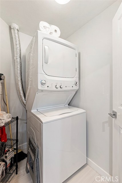 Separate laundry room with stackable washer/dryer