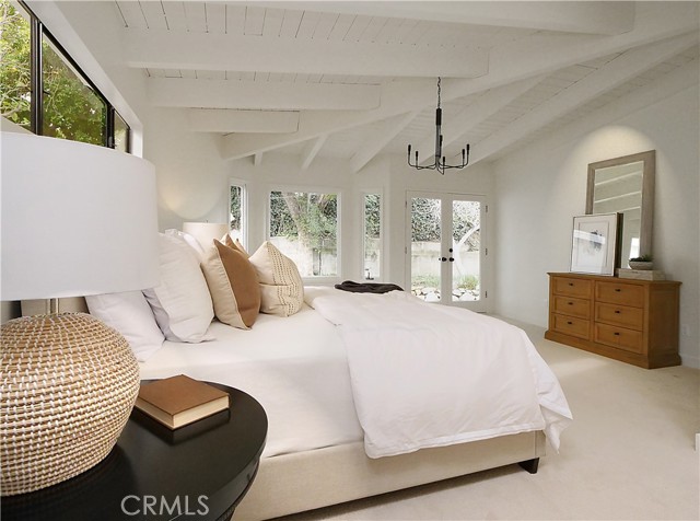 Primary bedroom with doors leading to side yard