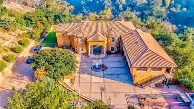 Gorgeous Luxury Custom Built Estate-One of a kind panoramic City lights view. The grand entry with magnificent wrought iron door sweeps into foyer that leads to living room with majestic stone fireplace. Gourmet kitchen features Thermador stove top, built-in oven with warming oven and microwave combo also features walk in pantry with additional sink and lots of cabinets. Formal dining room with hand painted crown molding Master Suite features dual fireplace to jacuzzi, balcony, walk-in closets, lighted custom moldings. Spectacular backyard with awesome view. The home is finished with travertine floors, hardwood floors and exotic granite countertops security system, intercom system, fire sprinklers, custom audio entertainment system, elevator, and many more custom amenities. must see to appreciate. Please call listing agent for a private showing appointment