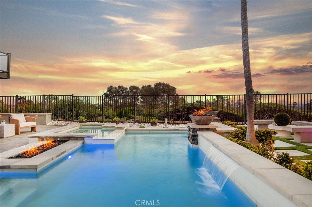 Welcome to 2 Hyannis, a truly exceptional coastal home nestled in the heart of the prestigious Beacon Hill Village community in Laguna Niguel. With its panoramic ocean views, custom-designed outdoor living spaces, and ideal location just minutes from Southern California’s most coveted beaches, this four-bedroom, three-bathroom residence embodies the relaxed elegance and indoor-outdoor lifestyle that defines life along the coast. Set on an oversized lot, the home’s true centerpiece is its breathtaking backyard—a private resort-style retreat that offers both sophistication and serenity. Framed by lush landscaping and designed with entertaining in mind, the outdoor space features a sparkling pool and spa, a built-in fire pit, and multiple seating areas perfect for both intimate gatherings and larger celebrations. At the heart of it all is an outdoor culinary pavilion unlike any other, complete with a built-in barbecue, elegant porcelain countertops, a bar area with a sink, refrigeration, and even a kegerator—an entertainer’s dream come true. This backyard provides a seamless extension of the home’s refined interiors and captures the essence of coastal California living. Inside, the home offers a thoughtfully updated living space. The open-concept living and dining areas are anchored by a custom fireplace and flow effortlessly into a remodeled kitchen appointed with quartz countertops and top-of-the-line stainless steel appliances. A versatile fourth bedroom or office with custom built-ins, a full bath with a walk-in shower, and access to the two-car attached garage complete the main level. Upstairs, the primary suite offers a peaceful escape with a large walk-in closet, a newly renovated spa-inspired bathroom, and a private balcony that captures sweeping ocean vistas and warm sea breezes. Two additional bedrooms and an elegant full bathroom round out the upper level. Set high above the Pacific in the hills of Laguna Niguel, Beacon Hill Village is a community celebrated for its coastal charm, lush greenbelts, and proximity to Dana Point Harbor, Salt Creek Beach, and world-class resorts like the Waldorf Astoria and the Ritz-Carlton. Known for its scenic trails, top-rated schools, and a spirit of refined leisure, Laguna Niguel offers a lifestyle that is both vibrant and tranquil—where the pace slows enough to savor each moment. At 2 Hyannis, every detail has been designed to elevate everyday living while creating unforgettable moments with family and friends.