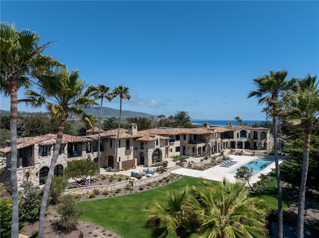 One of just a small collection of estate properties sited along the oceanfront of Southern California’s majestic coastline. A panoramic expanse of blufftop land spanning nearly three acres, and a refined residential compound with arboreal, verdant grounds and lush gardens are set before a spectacular tableau of sea, sky, and sunsets. The idyllic respite is exceptionally private, protected by both guarded community, and property gates, while the oceanfront elevation is cloistered by an avenue of magnificent mature cypress. The main house and guest quarters were originally directed in 2007 by acclaimed local architect James Glover, to reflect Spanish Colonial and Mediterranean influences, and perfectly capture the elements of the natural setting. Over the last several years, the interior and exterior environs were completely reimagined. Every detail was considered to enhance the generous presentation – the finest materials and construction processes were employed, redefining the property and its elegant yet intrinsically livable spaces. The six bedrooms, eleven baths, myriad formal and informal dwelling and entertaining areas, along with a separated guest house are now refined by a sophisticated, neutral palette and assemblage of enlightened furnishings and finishes. An enchanting compilation of opportunities to enjoy the sublime seaside locale including terraces, secluded courtyards, meandering paths, and nearly 500’ of frontage with a 55-foot swimming pool are set above an uncommonly untouched beach and world class surf break. This remarkable property, its extraordinary attributes, captivating views, and rarefied location are an offering beyond compare.