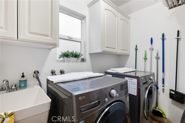 Good-sized laundry room on main level with sink and window + storage cabinets!