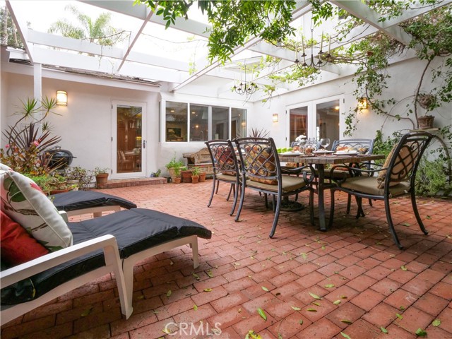 Arbor covered brick patio accessible from both kitchen and family room