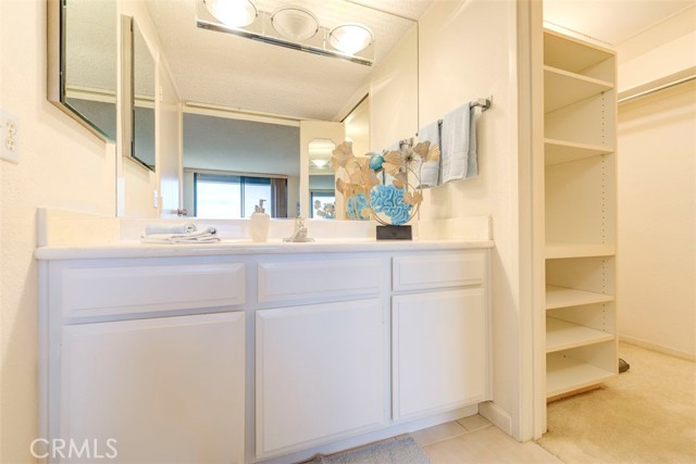 MASTER VANITY AREA WITH PARTIAL VIEW OF OVERSIZED WALK IN CLOSET