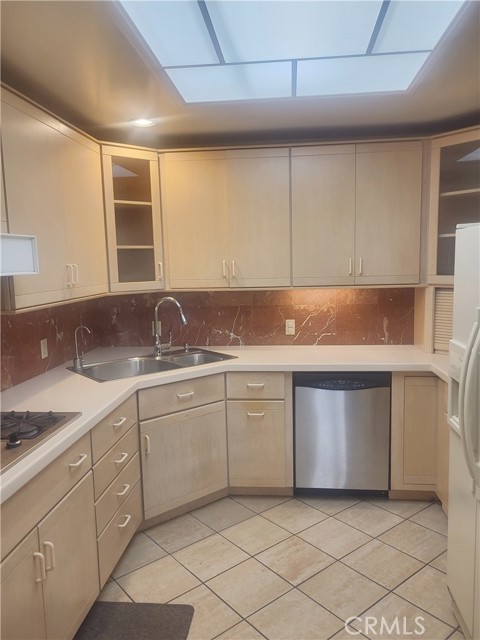 View Of Conveniently Placed Corner Sink For Easy Cleaning Between Gas Cooktop & Dishwasher