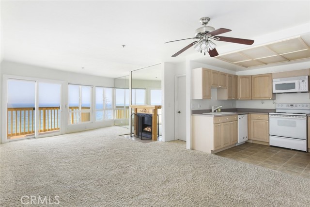 Kitchen, dining area, living room, fireplace, and balcony.