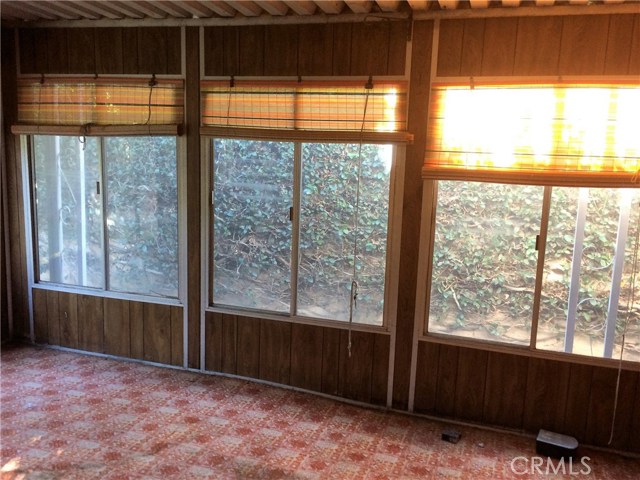 Covered patio with door leading out to private, peaceful backyard.