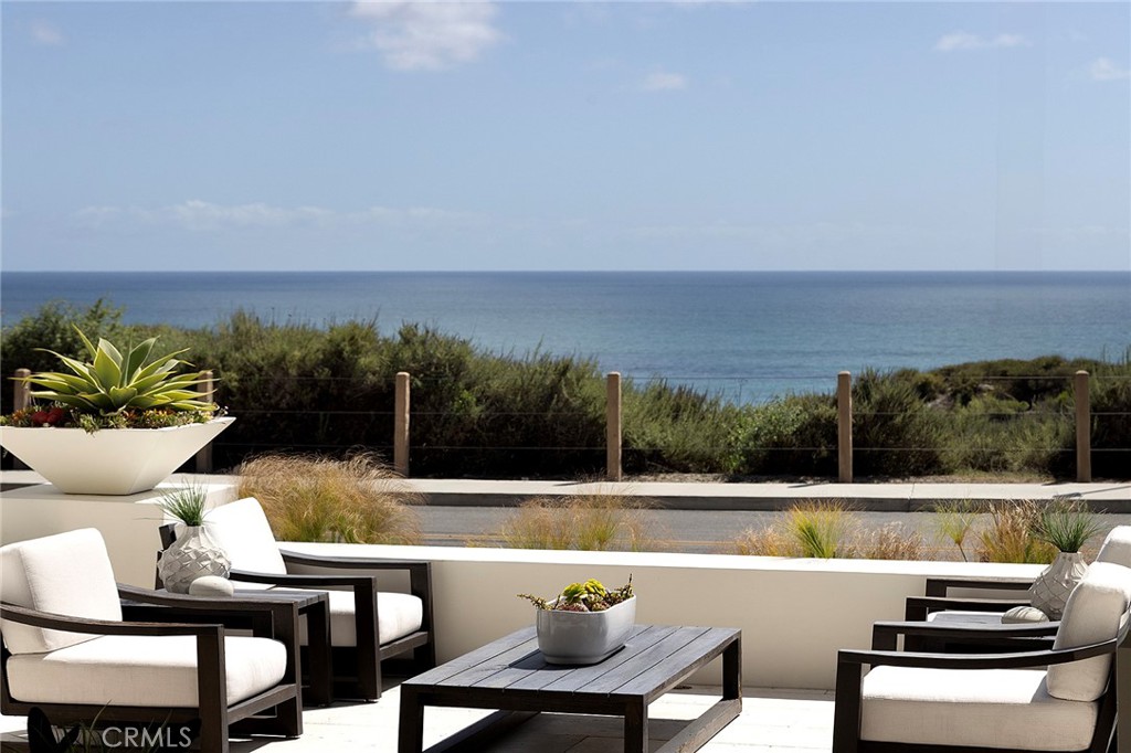 From the historic San Clemente Pier to Dana Point’s sculpted Headlands and the distant silhouettes of Catalina Island, sweeping panoramic views of the Pacific form the ever-changing backdrop to this custom-caliber residence—an elevated offering within the Azure Viewpoint Collection at Sea Summit in San Clemente. Ideally positioned on a single-loaded cul-de-sac framed by protected coastal bluffs, canyon trails, and the raw beauty of preserved open space, the Mediterranean-inspired home welcomes with a covered front patio and fireplace, extending into a sun-drenched ocean-view terrace wrapped in curated hardscaping and lush landscape design. Inside, an expanded floorplan of approximately 4,880 square feet unfolds with quiet grandeur—offering four ensuite bedrooms and four-and-one-half baths, including a refined main-level suite. Soaring ceilings, wide passages, and disappearing walls of glass create a seamless dialogue between indoors and out, with custom built-ins framing the great room’s fireplace and carrying into a dining room that connects effortlessly to both the backyard and an exquisitely appointed kitchen. The kitchen itself is magazine-worthy: a generous quartz island with seating for six, white Shaker cabinetry, artisan tilework, dual pantries—including a walk-in with integrated beverage station—and professional-grade appliances by Sub-Zero, Wolf, and Asko. A dramatic staircase, anchored by a custom desk niche, leads to a sunlit landing, versatile bonus room, and a serene primary suite where a covered balcony captures the horizon. The suite offers a retreat-like sitting area, boutique walk-in closet with direct laundry access, and a spa-like bath with freestanding tub, dual-entry shower, and uninterrupted views of whitewater and sky. Outside, a private loggia, cascading spa, open-air fireplace, and built-in BBQ kitchen complete the home’s outdoor experience—crafted for unforgettable entertaining. Built by acclaimed luxury builder Taylor Morrison, this residence enjoys access to the exclusive Summit Club, a 21,000-square-foot coastal haven with ocean-view pool, spa, fitness center, and entertaining lounge. The Sea Summit lifestyle also includes award-winning schools, access to trails and beaches, and proximity to the shops and dining of the Outlets at San Clemente.