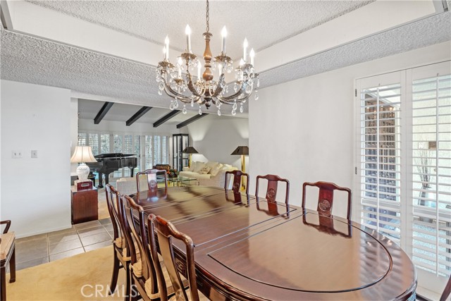 With room for 10+ seating, this formal dining room is stylishly appointed with a recessed ceiling and corner windows.