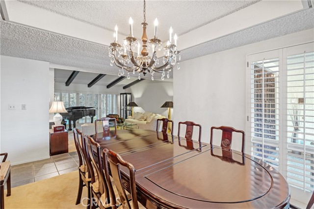 With room for 10+ seating, this formal dining room is stylishly appointed with a recessed ceiling and corner windows.