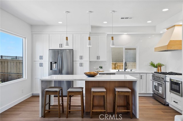 The pendant lights match the white and wooden tones in the kitchen.