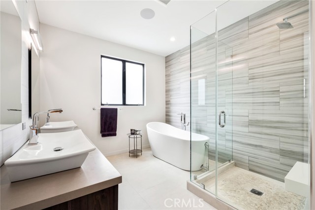 Luxurious primary bathroom with double vanity, private water closet and separate tub and shower