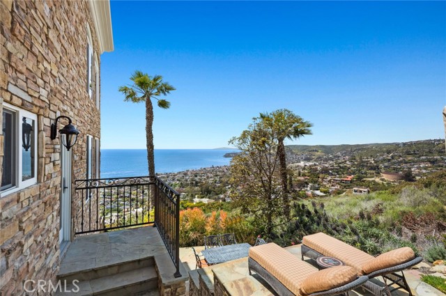 A side yard and deck offers sit-down views, privacy, a spa, and an outdoor kitchen with a built-in BBQ.