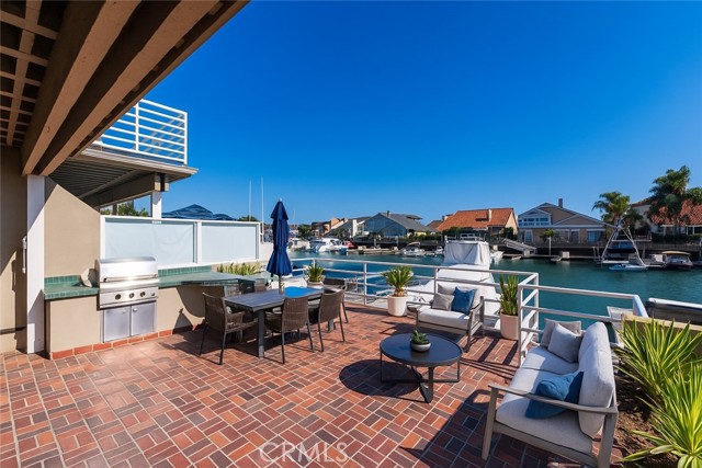 Virtually Staged-Large waterfront patio with built in grill and bar space.