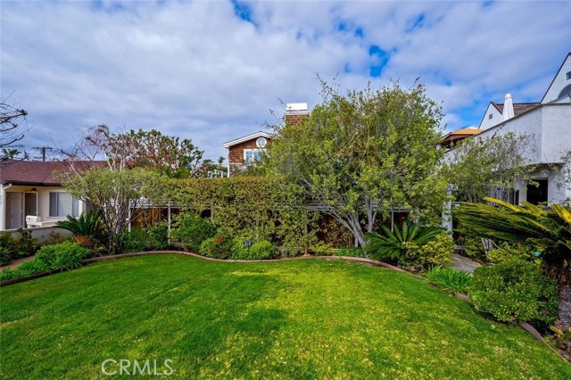 Large front yard with grass lawn. Spring will soon bring more color to the trees and flowers.