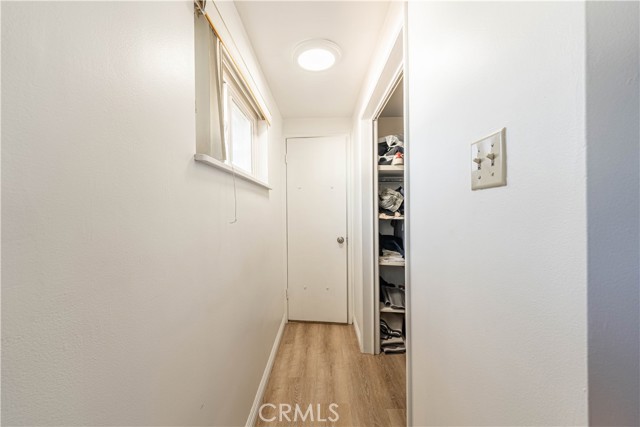 Hallway in primary bedroom leads to roomy walk in closet then primary bathroom