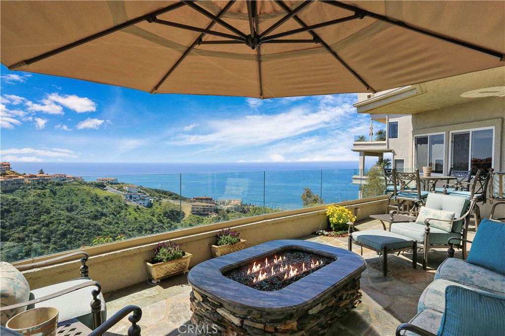 Perched high atop a lush canyon bluff, this luxurious designer home offers an unparalleled blend of elegance, tranquility, and breathtaking panoramic ocean views. The premier front row location is ideally situated on the end of a cul-de-sac in the exclusive guard gated enclave of Laguna Sur, overlooking picturesque coastline vistas out to Catalina Island and beyond. The custom etched glass double-door entry leads into the grand foyer with soaring ceilings, wrought iron stairway, & travertine flooring; all illuminated by a dramatic skylight. The home encompasses three levels of refined living space, each with ocean views and meticulous attention to detail throughout such as crown moldings, custom built-ins, upgraded doors, designer window treatments, & integrated speakers. Gourmet kitchen w/granite counters, wood floors, custom cabinetry, & SubZero wine fridge that opens to a separate breakfast nook bathed in natural light. The main level also features the formal living room w/marble fireplace, as well as a family room w/marble fireplace and dining area w/floor-to-ceiling sliding glass doors leading out to the deck; a perfect place to gaze out at the stunning sunsets. Spanning the entire upper level, the expansive primary suite exudes ambiance, warmed by a cozy double-sided fireplace. The en-suite bathroom is a sanctuary of relaxation; featuring a lavish soaking tub, travertine surrounded shower, & dual vanities remodeled w/granite counters & custom cabinetry. Large walk-in closet designed w/custom floor-to-ceiling wardrobe cabinets. The serene primary retreat features a custom built-in w/desk, and the cushioned bay view window seat is an inviting spot to take in the view & unwind. The lower level features two well appointed bedroom suites & a massive bonus room w/custom wet bar & wine cabinet. The oversize patio can easily accommodate a large gathering, and is ideal for entertaining w/ample seating space, custom Fire and Ice Firepit, & granite bar w/53" Viking grill & built-in refrigerator. Two-car garage is epoxy coated, w/built-in cabinetry & extra storage loft. Residents enjoy convenient access to amenities within the community such as heated pools, lighted tennis/pickleball courts, & scenic walking trails leading down to the beach. Experience the very best in California coastal living, conveniently located just a few minutes away from world class resorts such as The Montage Laguna Beach, Waldorf Astoria, and The Ritz Carlton in Monarch Beach.