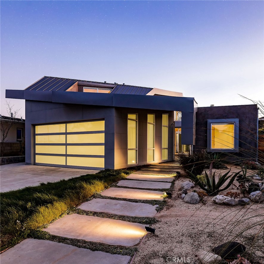 1309 S Irena Avenue in Redondo Beach, envisioned and brought to life by the lauded Los Angeles architect Patrick Tighe, is a testament to the transformative power of modern design. Nestled in the heart of suburban, beachy South Redondo, this 3 bedroom, 3.5 bath, 2819 sq ft home is a striking edifice of both clean minimalism and functional luxury. Signature Patrick Tighe, faceted volumes, cantilevered rooflines, metal cladding and expansive use of glass define the structure. The highly sculptural profile of folded metal roof planes creates a stunning façade, as larger, more expressive volumes rise to the west. Inside, the house offers an airy and spacious feel, as dynamic spaces flow through the home, with sleek bamboo and slate flooring, and layered geometric skylights. Strategically-oriented floor-to-ceiling glass provides optimal transparency and brightness, while grounding the structure to its surroundings. Further blending the indoor and outdoor environments, the slender swimming pool extends directly from the edge of the entertainer’s kitchen, forming a strong axis in the Mediterranean-inspired landscape. Bask in the coastal breezes at each level, including several outdoor lounge spaces in the backyard at the fire pit cabana, or under wood pergola with the two-way fireplace. The master suite, featuring a walk-in closet and spa-like bath with separate shower and jetted tub, appears to float above the pool, wrapped in floor-to-ceiling glass. The roof decks offer fireside cocktail spaces and sweeping views of the twinkling lights dotting the Palos Verdes hillside, and sunsets to the west. Just a half mile from the sand, this must-see property seamlessly blends the best of beach lifestyle with the understated elegance of Tighe’s world-class design. WATCH THE VIDEO TOUR: https://bit.ly/1309sirena