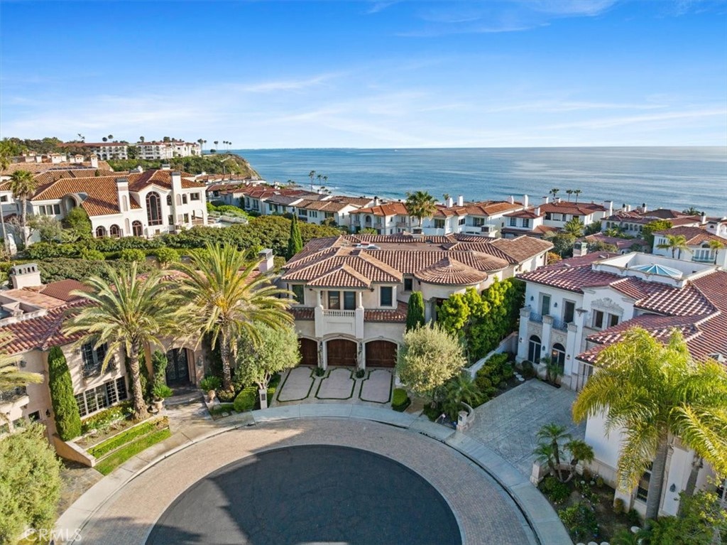 Experience unparalleled luxury in this ocean view home located in prestigious Ritz Cove. Every corner of this residence exudes elegance, with outstanding architectural details and meticulous trim work throughout. From intricately designed ceilings and doorways to beautifully crafted archways and murals, no detail has been overlooked. Step into a grand two-story foyer that sets the tone for the rest of the home. Beyond the foyer, a stunning pool glitters against the backdrop of the ocean, offering incredible views from both floors. Enjoy leisurely strolls to the beach, just a block away.  A water feature winds around the home, greeting you at the front door and continuing in the back yard, which is filled with flowering bushes and fruit trees. The home is equipped with a brand new HVAC system, a fabulous entertainment TV system and features opulent cabinetry, spacious closets, and a paneled wood office. An elevator provides easy access to three levels, from the garage to the first and second floor.  The primary suite boasts breathtaking whitewater views of nearby Monarch Beach. Over half a million dollars has been invested in casework alone, underscoring the quality and craftsmanship of this exceptional property.  Cove lighting provides beautiful ambiance for entertaining, and a walk-in Wine Room with a glass and iron door is just off the family room area which hosts an incredible curved bar. Situated at the end of a quiet, single-loaded cul-de-sac, this luxurious residence offers both privacy and tranquility. Rarely does a home of this construction and detail come to market. Guard-gated Ritz Cove is nestled between the luxurious Ritz Carlton and Waldorf Astoria resort hotels, in a spectacular guard-gated enclave of just 101 homes. Don’t miss the opportunity to own this extraordinary property.